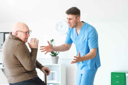 A male nurse yelling at an elderly man.